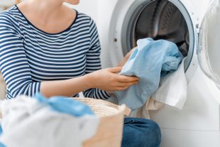 woman is doing laundry at home. laundry machine and hands close up